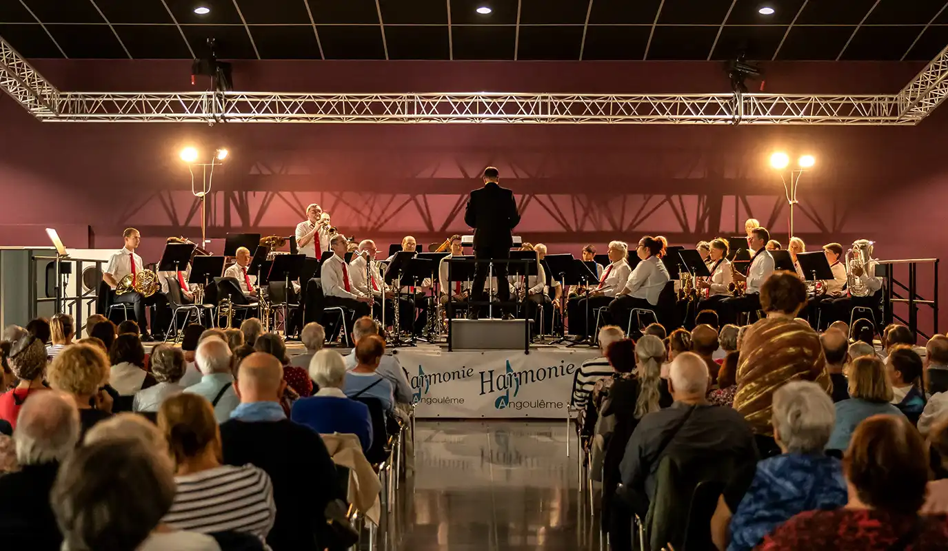 L'Harmonie d'Angoulême lors de son concert des 150 ans. L'orchestre sur scène, dirigé par Jean-Baptiste Burn. Un soliste à la trompette est debout.